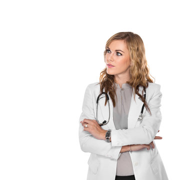Young female doctor look away with arms crossed, isolated