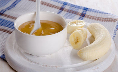 Baby food - bananas puree in  white bowl.