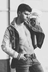 Handsome young man with blue eyes posing in urban background