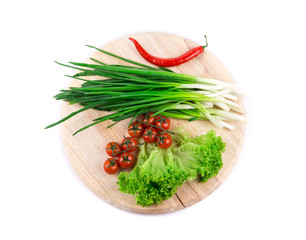 Bunch of green onion on wooden platter.