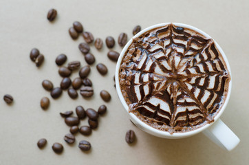 A cup of coffee with latte art on brown paper background
