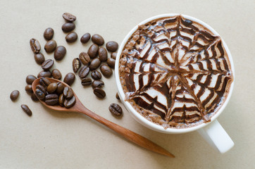 A cup of coffee with latte art on brown paper background