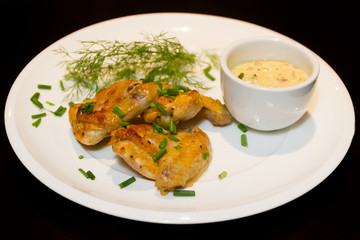 fried chicken wings served with source on white plate isoalted o