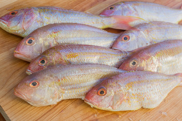 fresh fish on wooden cutting board ready for cooking