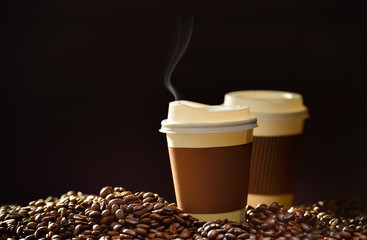 Paper cup of coffee and coffee beans on wooden table