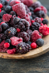 mixed frozen berries on wooden background