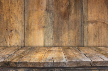 Grunge vintage wooden board table in front of old wooden backgro