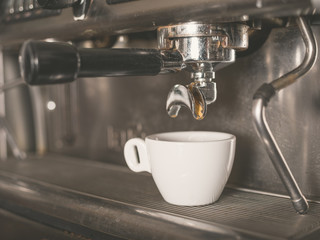 Coffee machine and a small white cup
