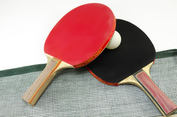 Two table tennis rackets and a net isolated