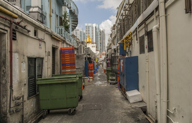 Fototapeta na wymiar A Back Ally in Singapore. with stacks of crates and wheel bins