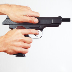 Hands reload handgun on a white background