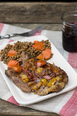 Pork chops with tomatoes on top with lentils and carrots