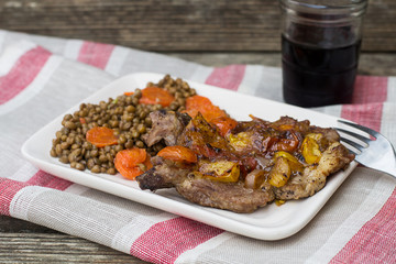Pork chops with tomatoes on top with lentils and carrots