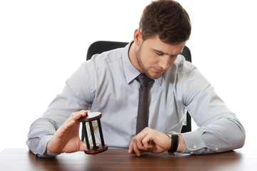 Businessman holding hourglass.