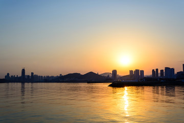 Obraz premium Silhouette of the city with sea at sunset