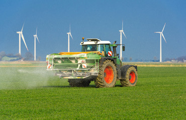XXX - Traktor mit Düngerstreuer auf dem Kornfeld - 8994