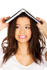 Student woman with a book on head.