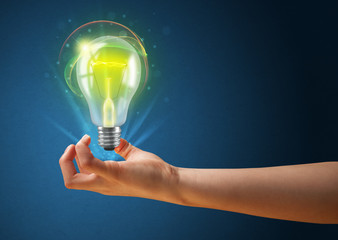 Glowing lightbulb in the hand of a woman