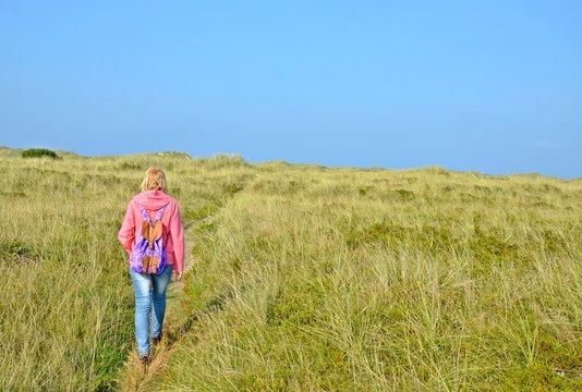 Frau spaziert in den Dünen