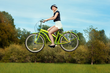 Fototapeta na wymiar Girl on bike flies.
