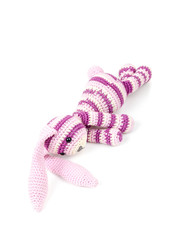 Sad knitted rabbit toy lays isolated on white