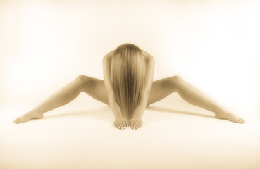 Frau nackt sitzt auf dem Boden nach vorne gebeugt