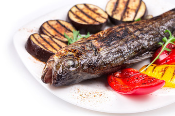 Grilled seabass with vegetables on plate.