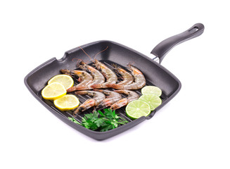 Raw shrimps on pan with lemon.