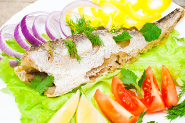fish hake baked with vegetables on a plate