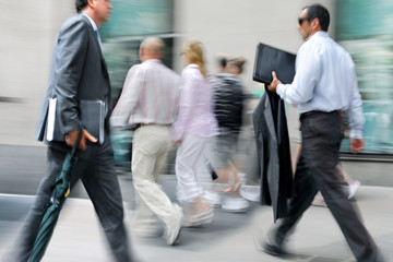 motion blurred business people walking on the street