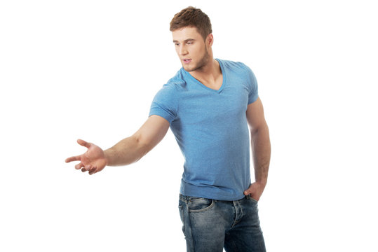 Handsome young man pointing down.