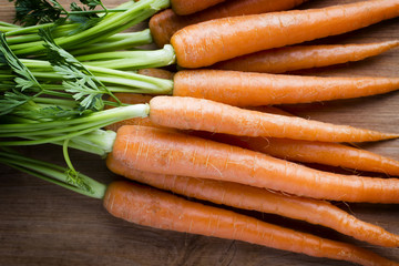 Fresh carrots on the wooden background.