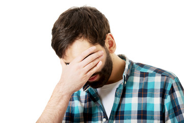 Fototapeta premium Young depressed man touching his face.
