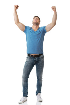 Young man with his arms up in victory gesture.