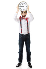 Man wearing suspenders holding big clock.