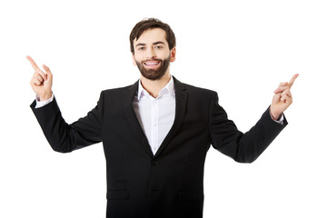 Happy businessman points his finger up.