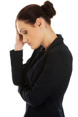 Tired businesswoman touching her head.