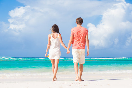 back view of happy romantic young couple on the beach