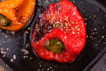 Tasty roasted red and orange bell peppers in pan
