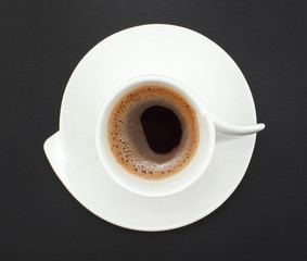 white cup of organic coffee on the background of black paper