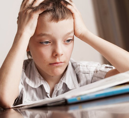 Sad boy doing homework