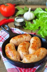 fried chicken sausages with vegetables on a frying pan