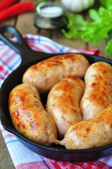fried chicken sausages with vegetables on a frying pan