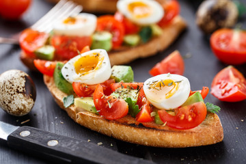 Bruschetta with tomato, avocado and quail egg