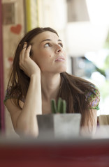 Young latin woman at street bar worried