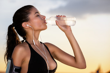 Young sporty woman drinking water
