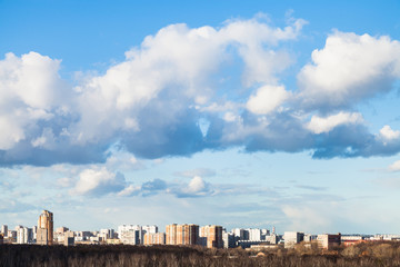 Fototapeta na wymiar clouds in blue spring sky over city