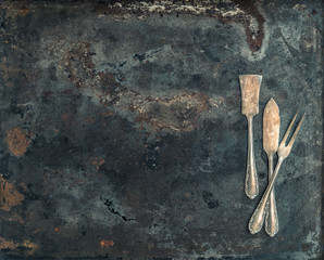 Antique silver cutlery on rustic metal background. Vintage table