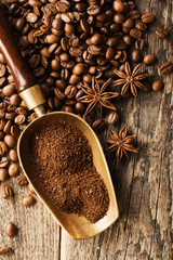 ground coffee in scoop and coffee beans on a wooden background