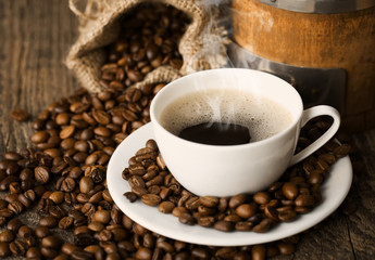 hot coffee and coffee beans on the background of coffee grinders